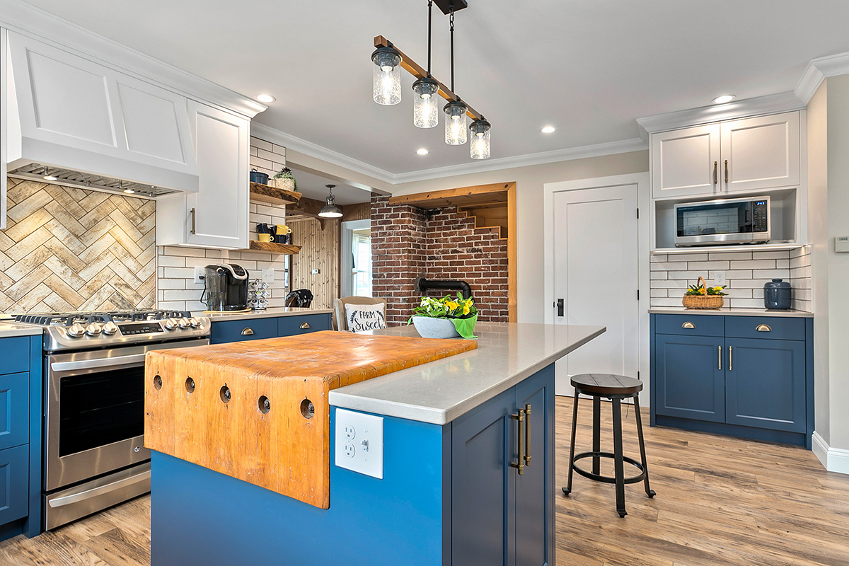 Blue cabinets and brick walls in a remodeled kitchen.