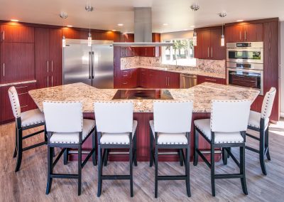 Curved island features built-in cooktop in kitchen remodel..